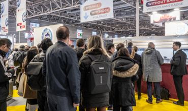 Crowd of visitors queuing at the entrance of a trade show in separated lines