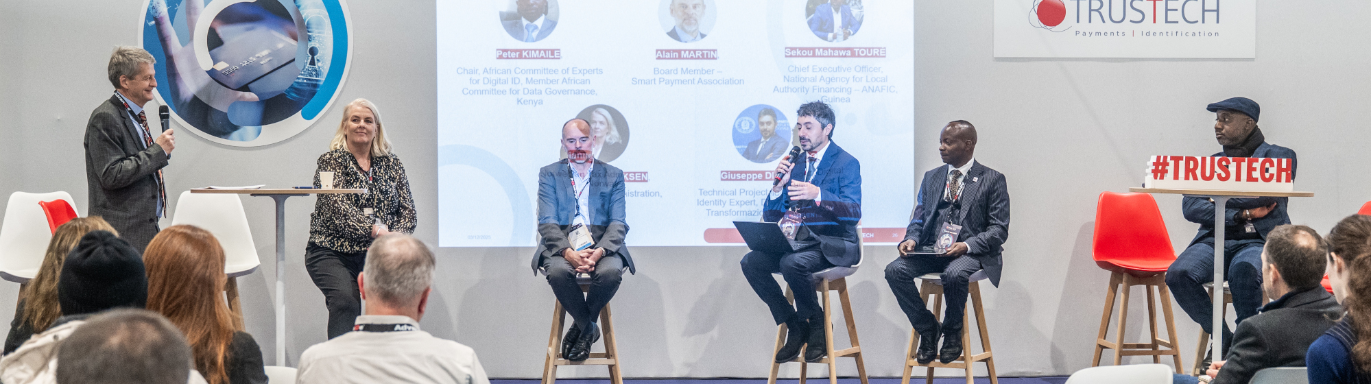 Round table at TRUSTECH 2025 featuring several speakers on stage talking about digital ID wallets, data orchestration, KYC, and payments