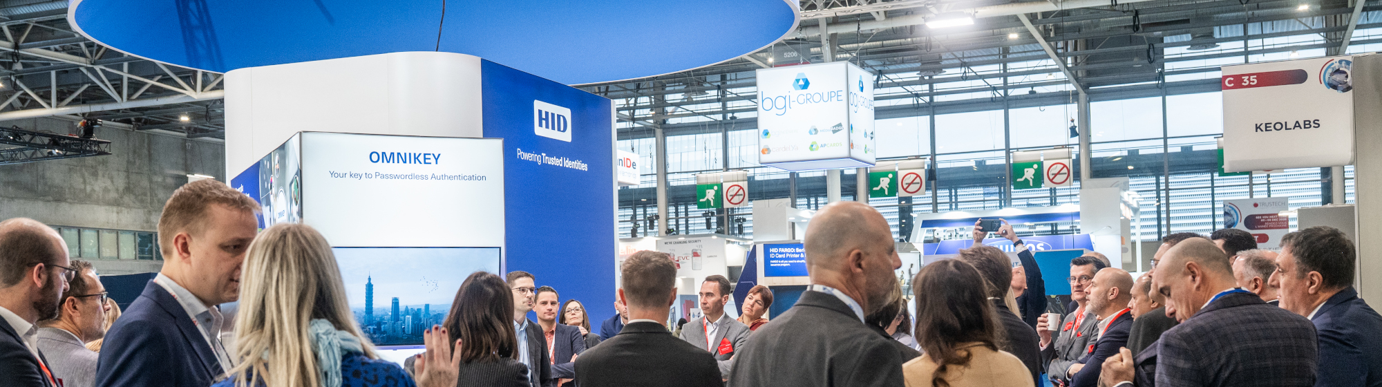 Visiteurs échangeant sur le stand HID dédié aux solutions d’identité numérique lors du salon TRUSTECH