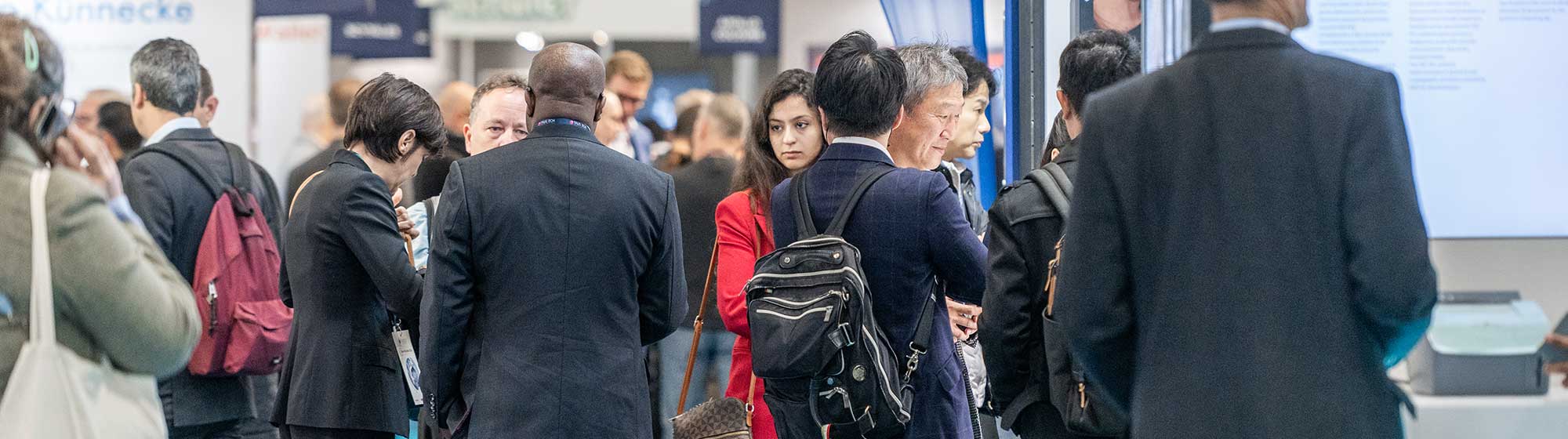 Visitors walking through Trustech event aisles