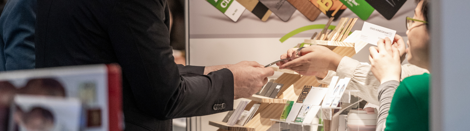 Visiteur devant un stand exposant avec des cartes exposées