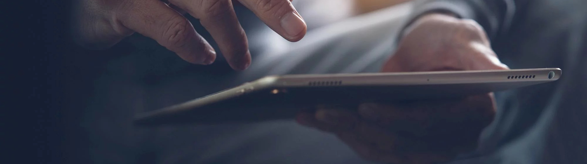 Hand using a touchscreen tablet to sign a document electronically.