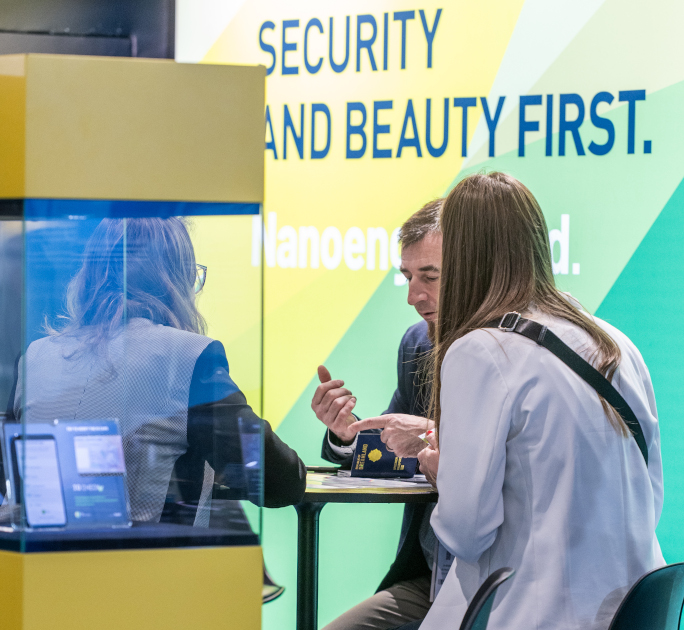 Participants en réunion sur un stand exposant à TRUSTECH 2025 autour de solutions de sécurité et d’identification