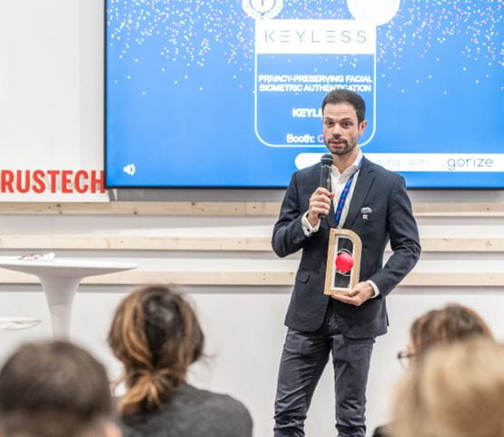 A man from Keyless, winner of the Start-Up Trophy at TRUSTECH, standing on the stage with an Award