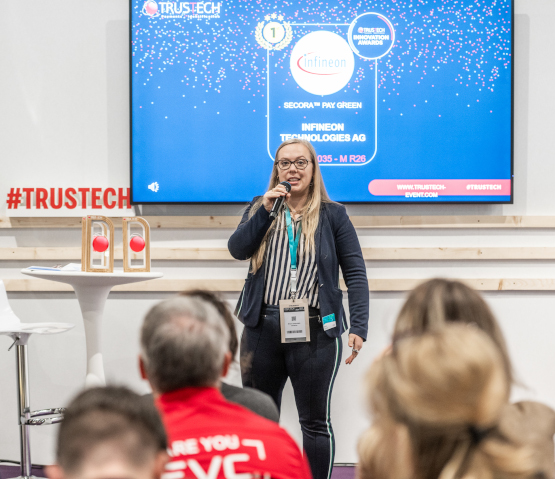 Une femme de Infineon, lauréat des TRUSTECH Innovation Awards, sur scène avec le trophée