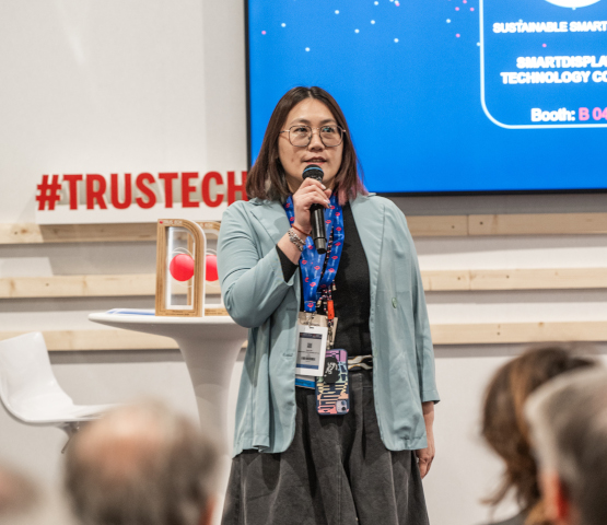 Une femme de Smartdisplayer Technology, lauréat des TRUSTECH Innovation Awards, sur scène avec le trophée