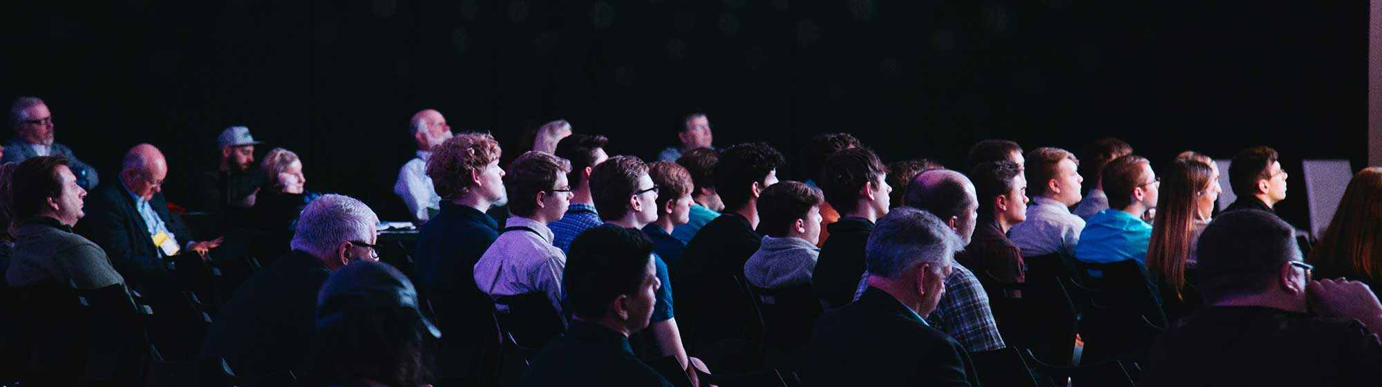 An audience taking notes during a press conference