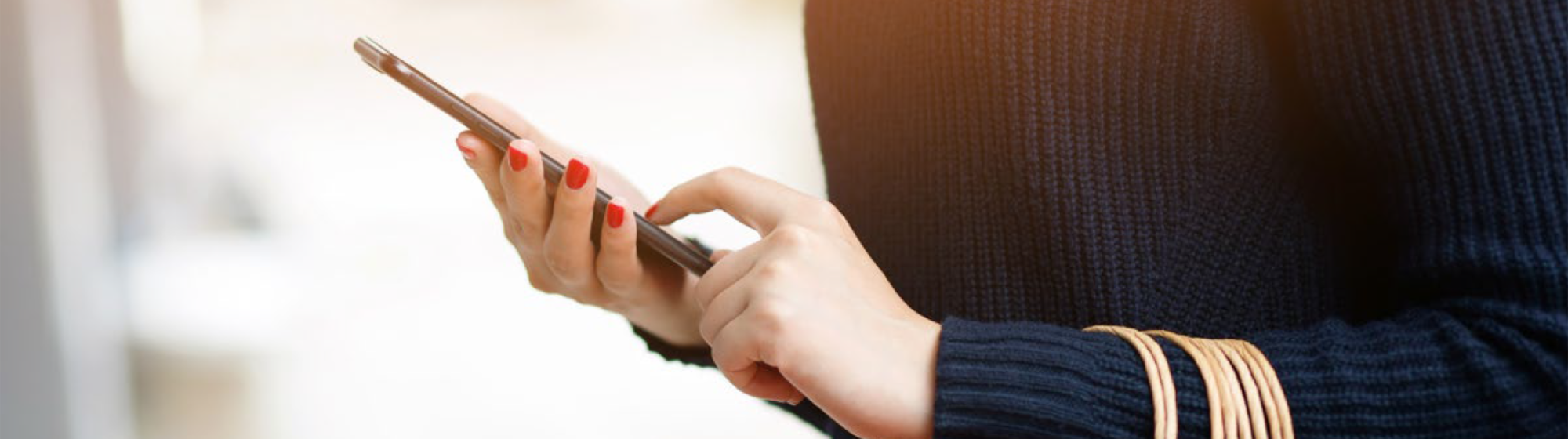 User checking their smartphone, illustrating a survey or digital interaction related to TRUSTECH