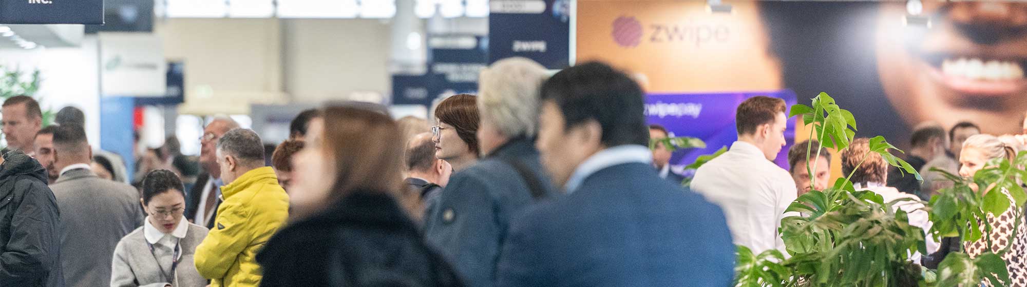 Crowd of visitors walking through TRUSTECH exhibition's aisles