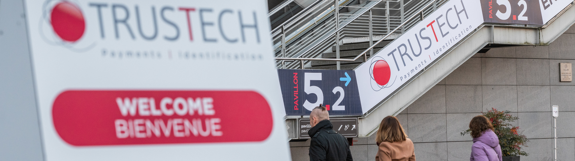 Vue de l’entrée du salon TRUSTECH avec la signalétique "Bienvenue" et l’indication du pavillon 5.2.